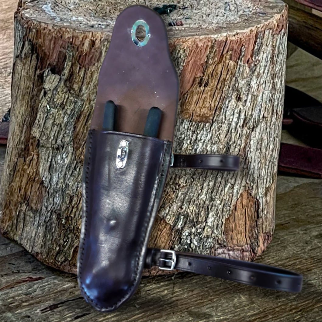 an image of a leather plier case with knippex pliers leaning against a log