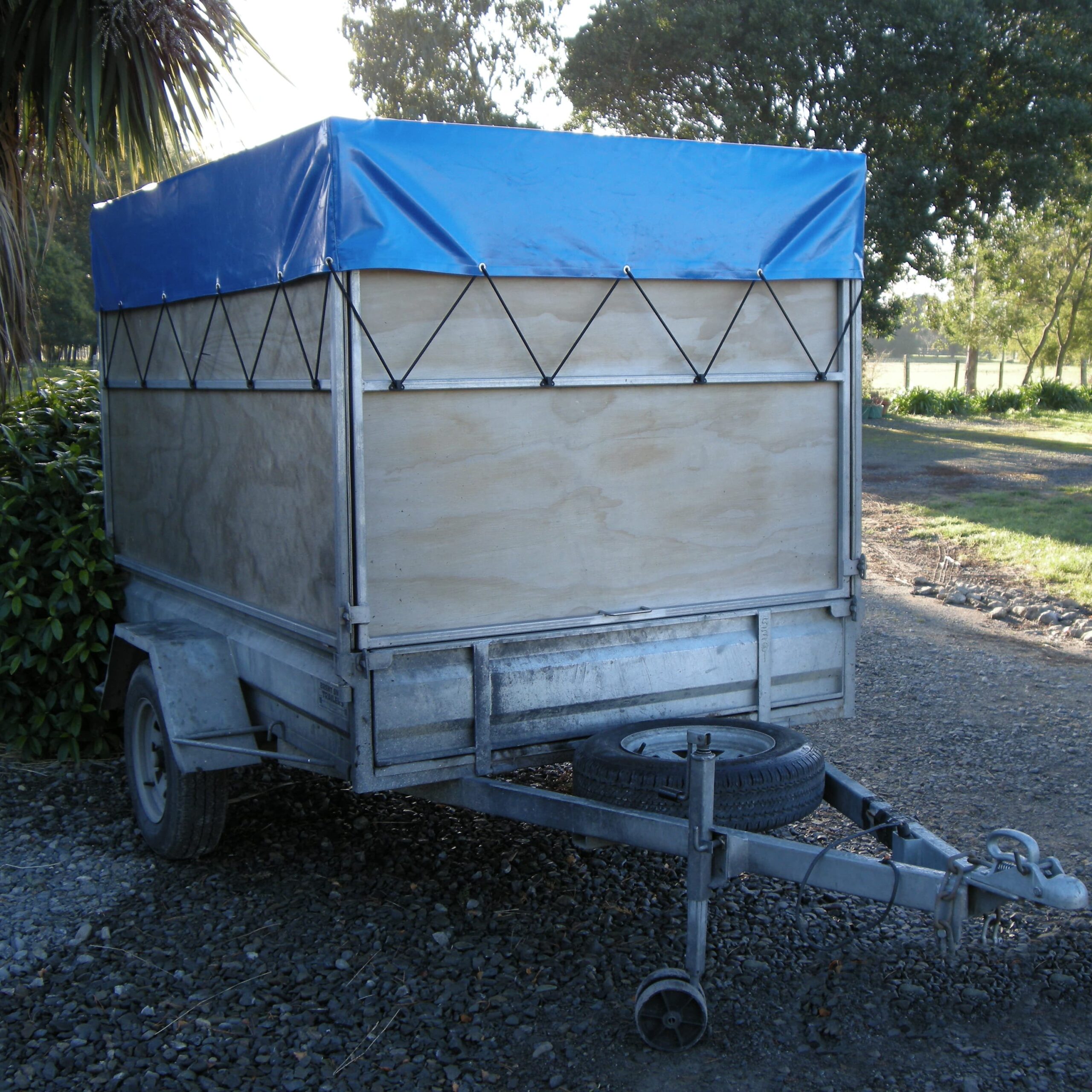 Picture of a trailer with a blue trailer cover on it made by Robertson Canvas